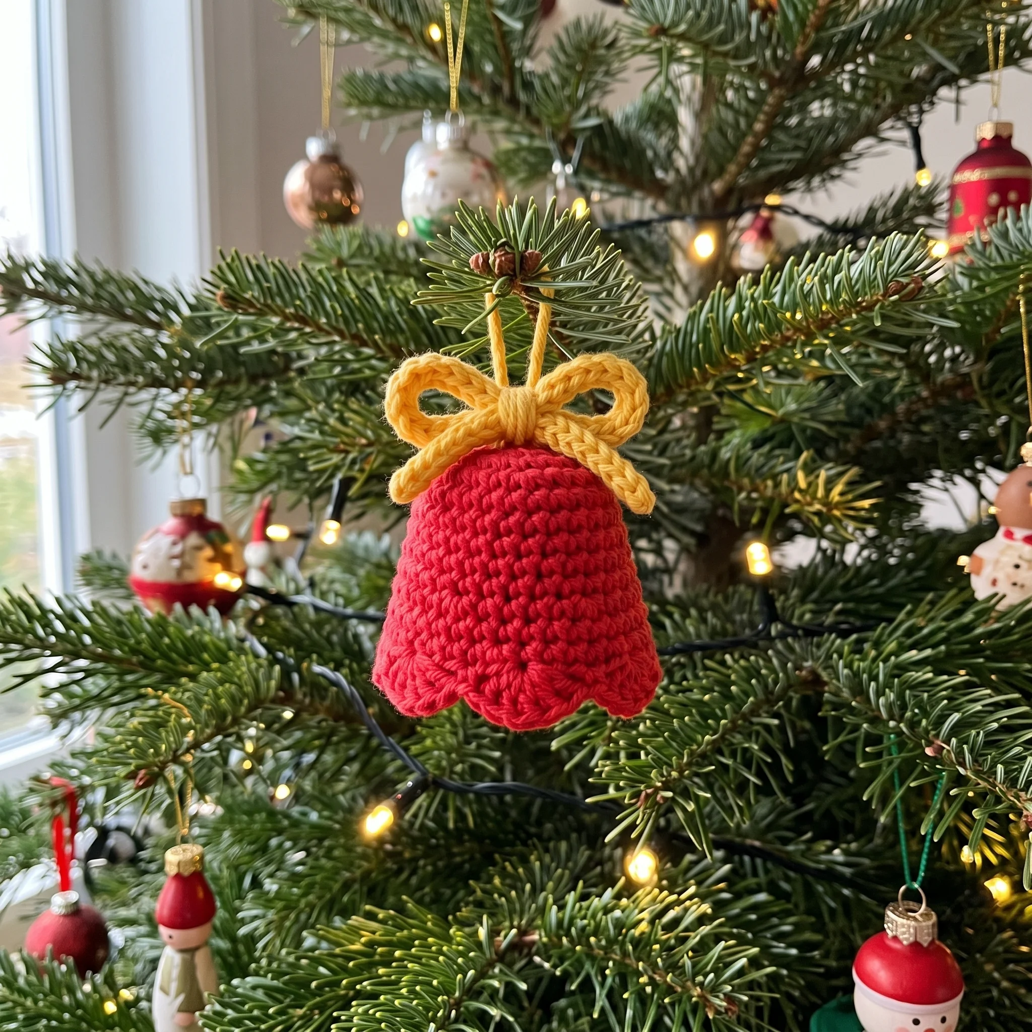 Crochet bell ornament hanging on a Christmas tree