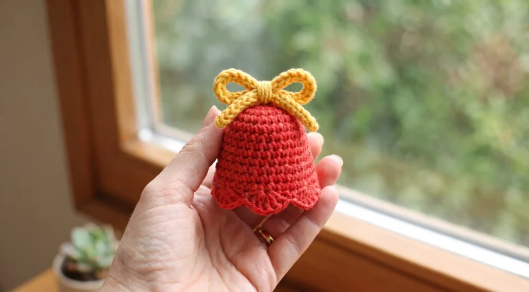 crochet bell ornament holding hand